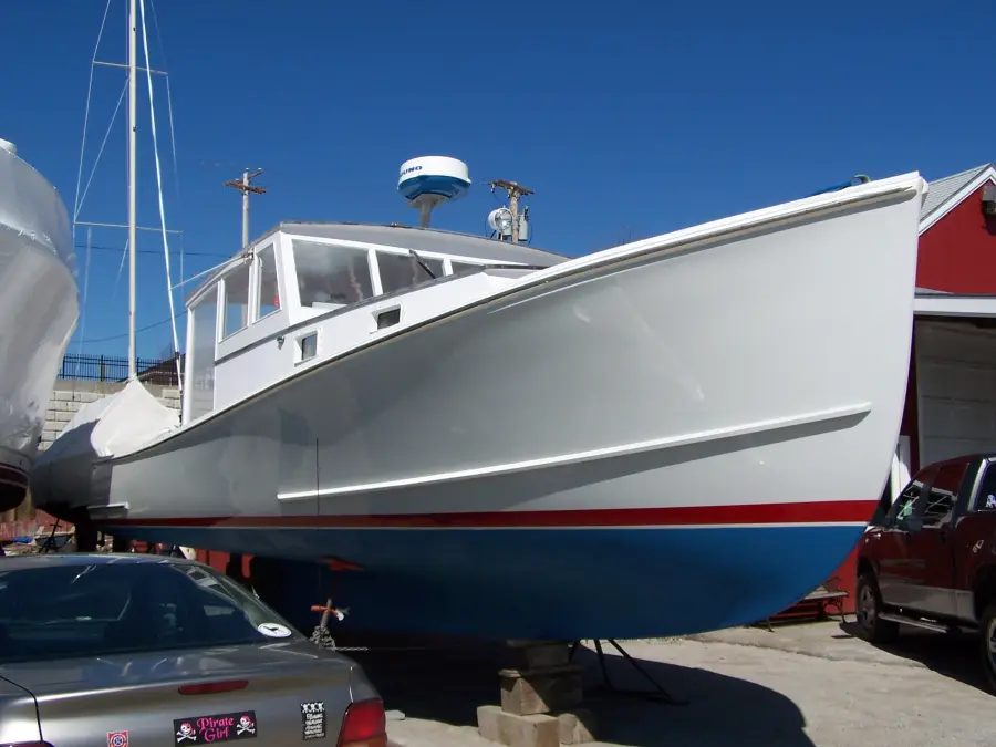 A freshly painted lobster boat on the hard